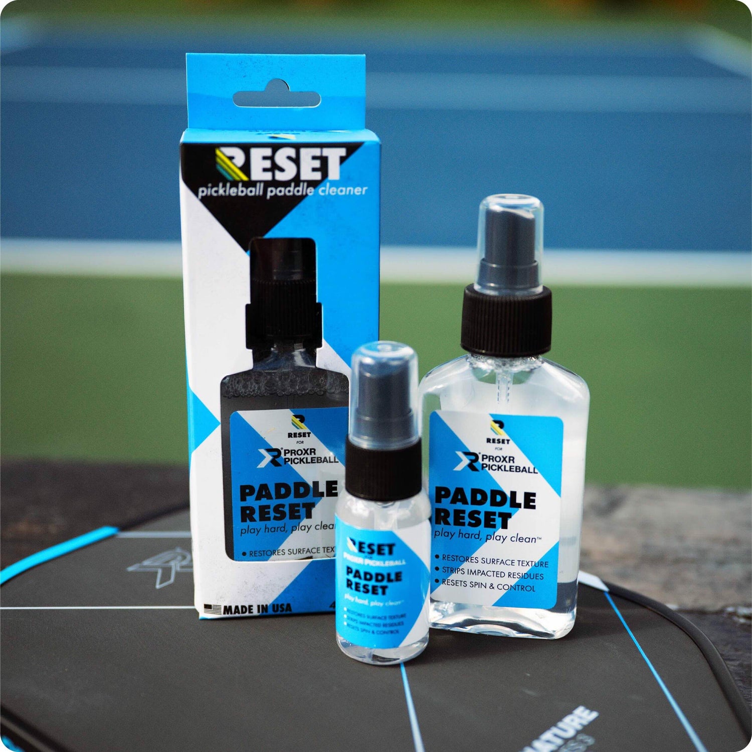 RESET pickleball paddle cleaner packaging and bottles on a pickleball paddle